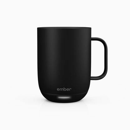 Ember Mug 2 on desk with smartphone showing temperature control app interface